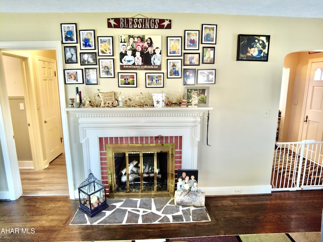 living room featuring a fireplace, a textured ceiling, and hardwood / wood-style flooring