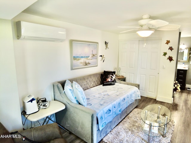 bedroom with an AC wall unit, ceiling fan, a closet, and dark hardwood / wood-style floors