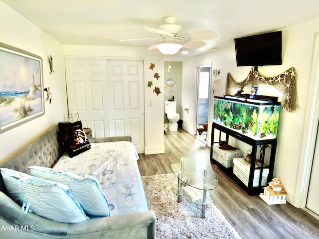 living area with hardwood / wood-style floors and ceiling fan