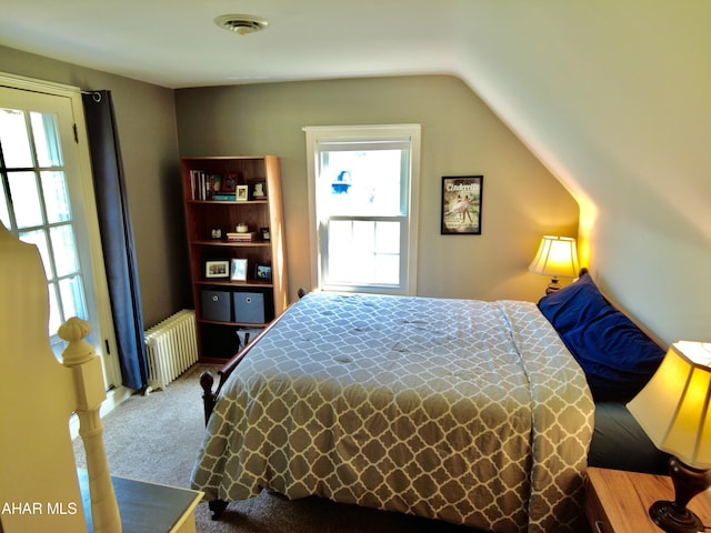 carpeted bedroom featuring radiator and vaulted ceiling