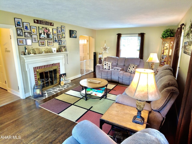 living room with a fireplace and dark wood-type flooring