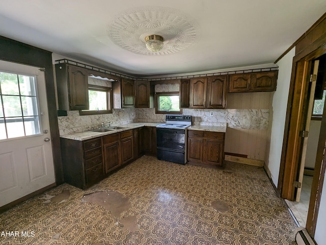 kitchen with backsplash, white electric range oven, dark brown cabinets, baseboard heating, and sink