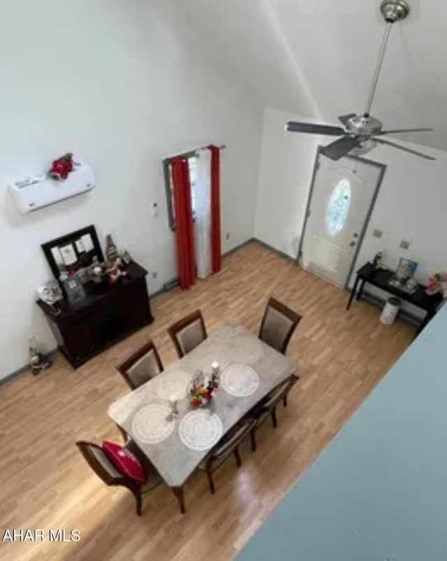 dining room featuring wood finished floors, a ceiling fan, and lofted ceiling