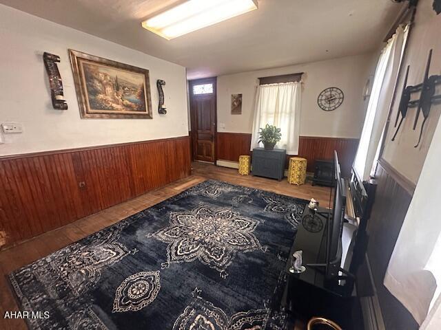 193 Pavia Rd, Imler, PA 16655 - hallway with wainscoting, wood finished floors, a baseboard radiator, and wood walls