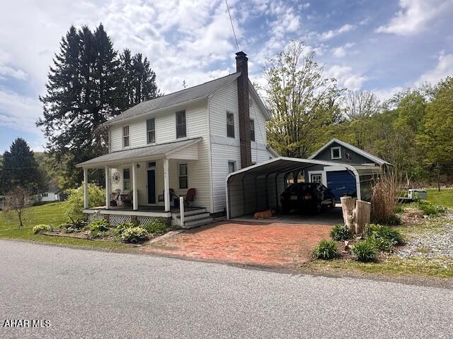 193 Pavia Rd, Imler, PA 16655 - country-style home featuring driveway, covered porch, a chimney, and a carport