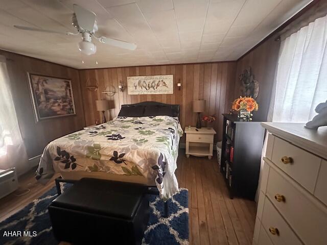 193 Pavia Rd, Imler, PA 16655 - bedroom featuring hardwood / wood-style flooring, wood walls, multiple windows, and a ceiling fan