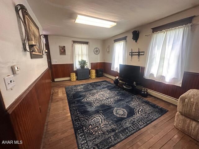 193 Pavia Rd, Imler, PA 16655 - sitting room featuring wainscoting, hardwood / wood-style flooring, wooden walls, baseboard heating, and a baseboard heating unit