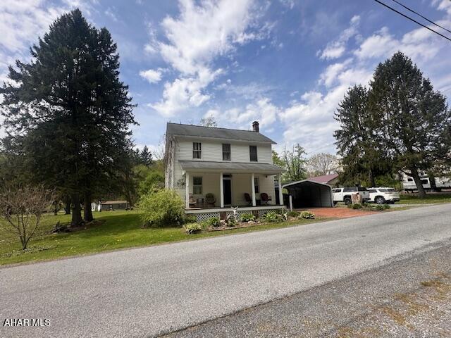 193 Pavia Rd, Imler, PA 16655 - country-style home with a detached carport, covered porch, a chimney, and a front yard
