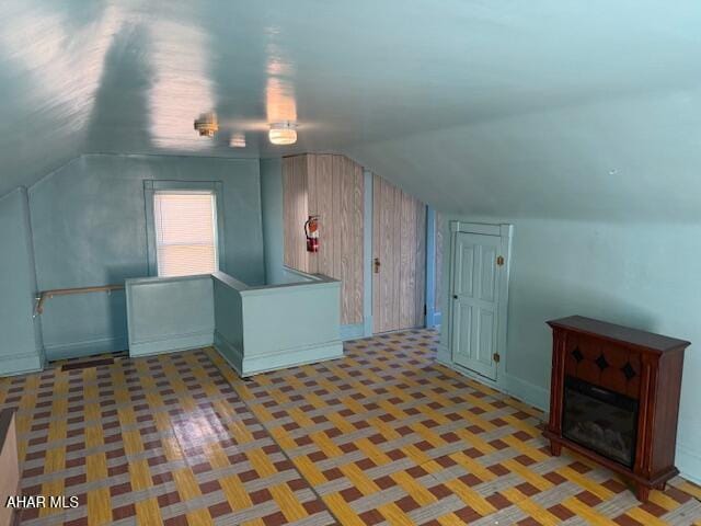 additional living space featuring lofted ceiling and baseboards