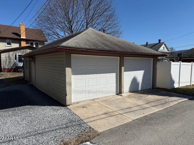 detached garage featuring fence