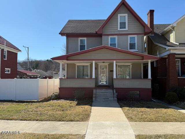 view of front of home with a porch and fence