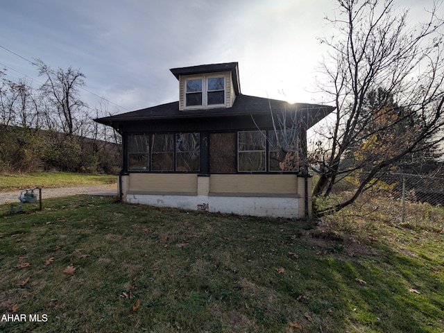 view of front of house featuring a sunroom and a front yard