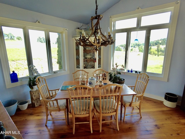 dining area featuring hardwood / wood-style flooring, plenty of natural light, and a chandelier