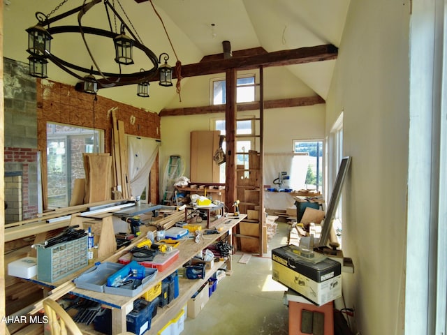 misc room featuring a workshop area, beamed ceiling, and high vaulted ceiling