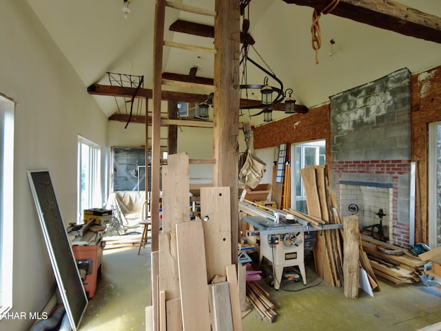 misc room with beam ceiling, high vaulted ceiling, and concrete flooring