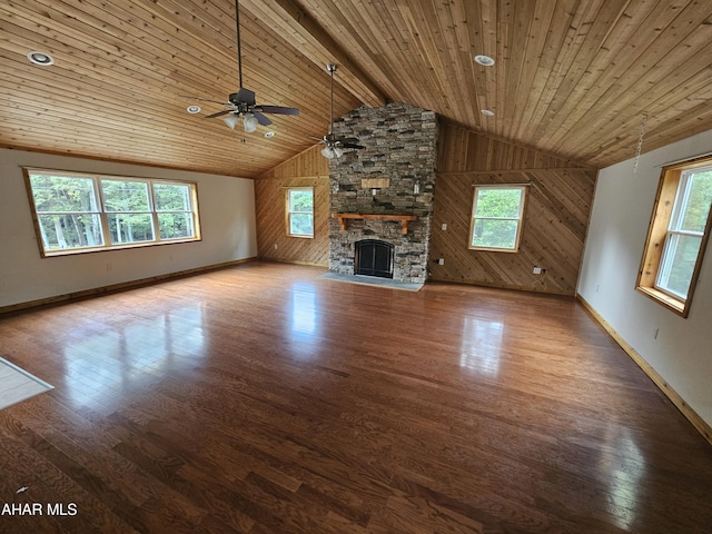 unfurnished living room with wood-type flooring, wooden ceiling, a fireplace, and a wealth of natural light