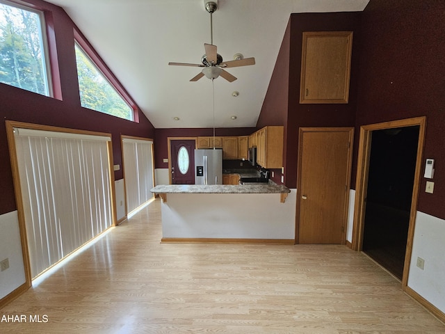 kitchen with stainless steel fridge, light hardwood / wood-style flooring, high vaulted ceiling, and ceiling fan