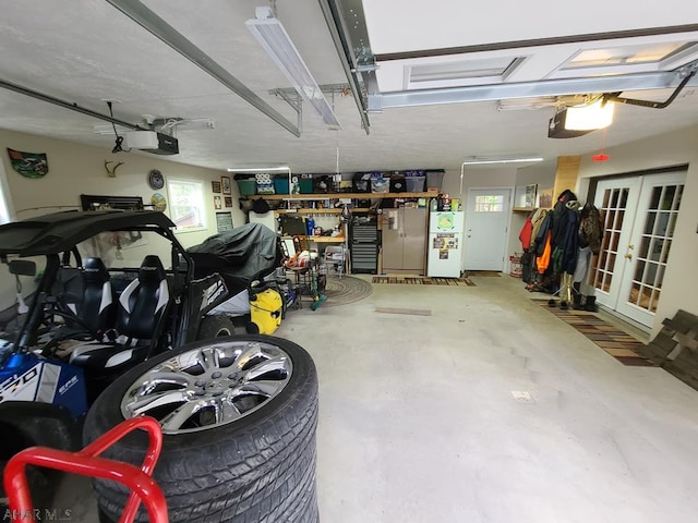 garage with a workshop area, a garage door opener, and french doors