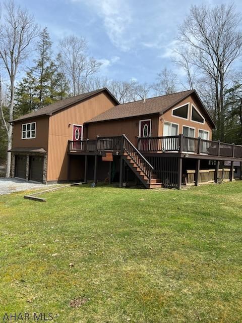 back of property with a lawn, a wooden deck, and a garage