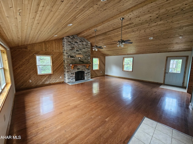 unfurnished living room featuring light hardwood / wood-style floors, vaulted ceiling, a wealth of natural light, and wooden ceiling