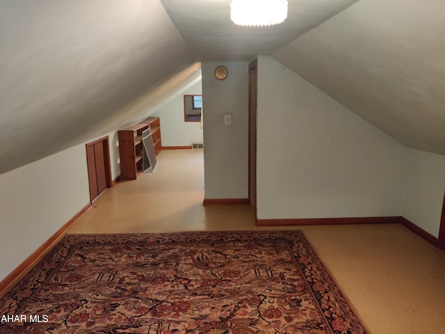 additional living space featuring carpet and vaulted ceiling