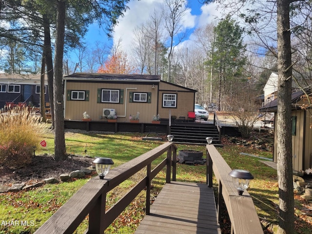 rear view of house featuring a yard and a wooden deck