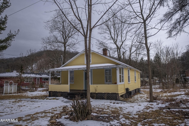 view of front of home featuring a porch and a chimney