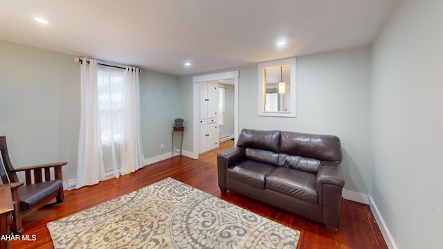 living area with baseboards, wood finished floors, and recessed lighting