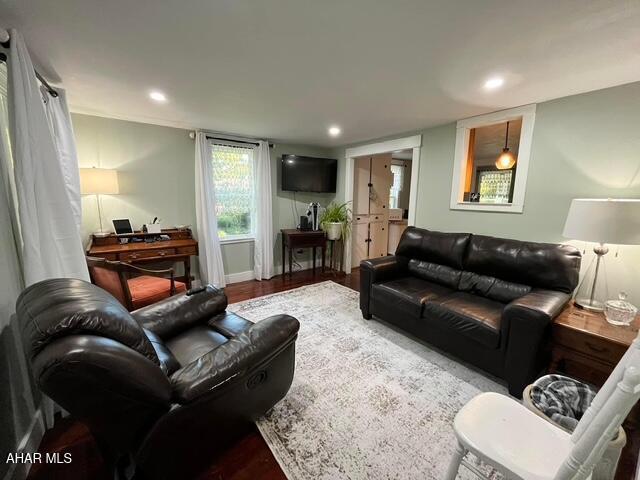 living room with baseboards, wood finished floors, and recessed lighting