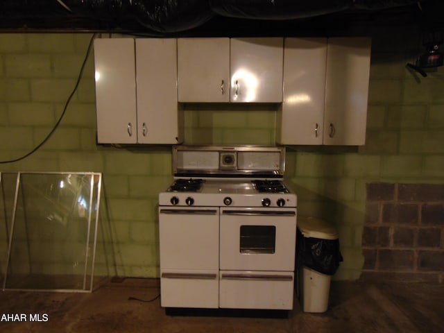 kitchen with range with two ovens and white cabinets