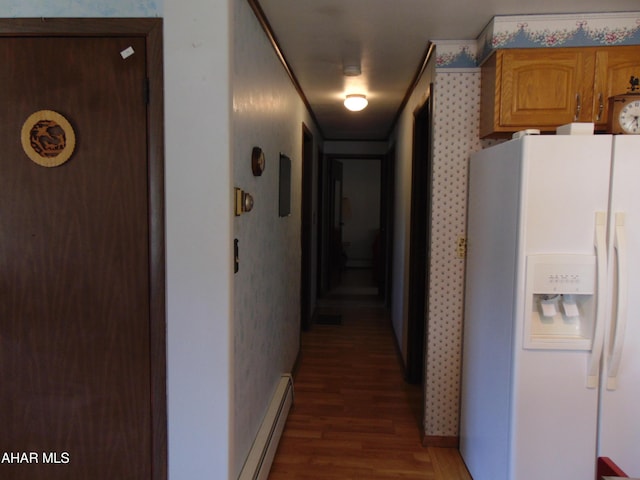 corridor featuring a baseboard heating unit and dark wood-type flooring