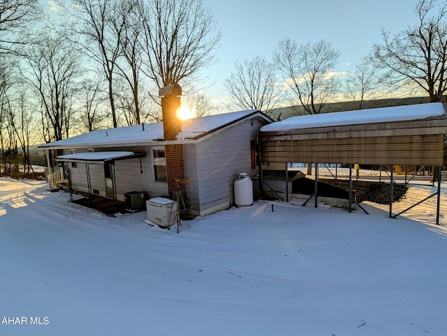 snow covered property featuring a carport