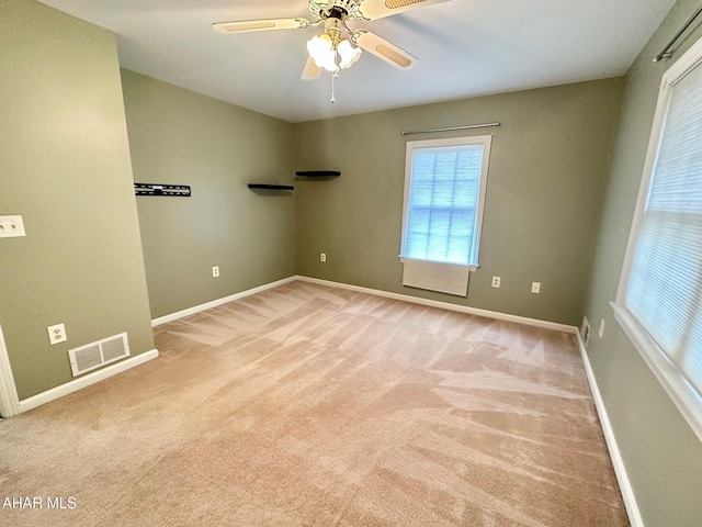 carpeted spare room featuring ceiling fan