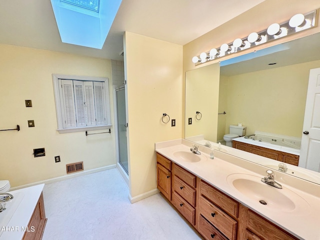 full bathroom featuring separate shower and tub, a skylight, vanity, and toilet