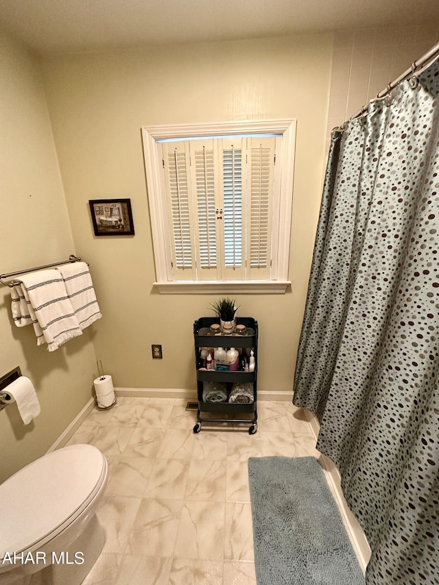 bathroom featuring a shower with shower curtain and toilet