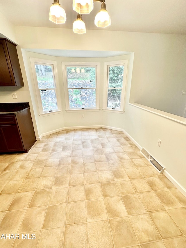 unfurnished dining area featuring a wealth of natural light and light tile patterned floors