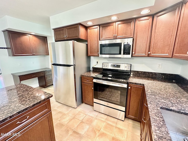 kitchen with dark stone counters and appliances with stainless steel finishes