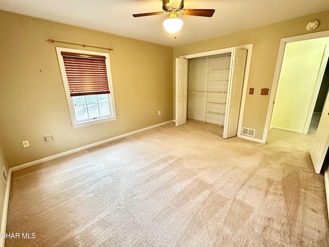 unfurnished bedroom with ceiling fan, light colored carpet, and a closet