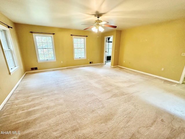 empty room featuring ceiling fan and light colored carpet