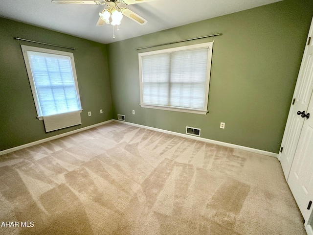 carpeted spare room featuring ceiling fan