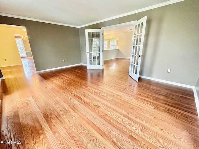 spare room featuring french doors, light hardwood / wood-style floors, and crown molding