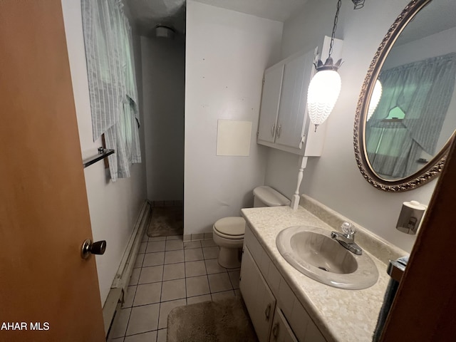 bathroom with tile patterned floors, toilet, vanity, and baseboard heating