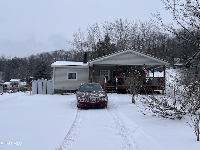 view of front facade featuring a shed and covered porch