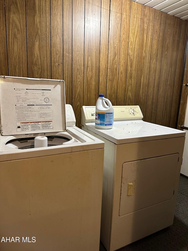 washroom featuring wooden walls and independent washer and dryer