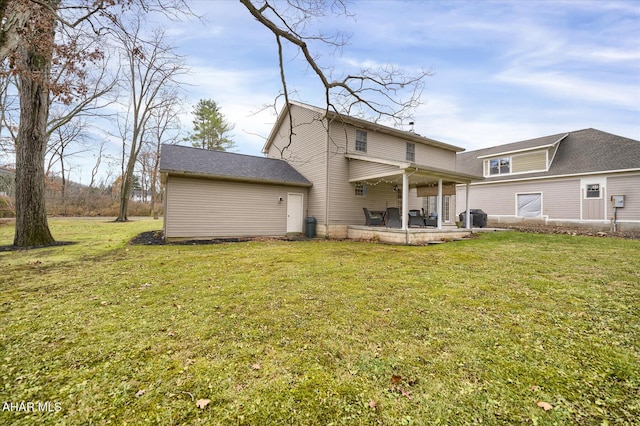 rear view of property featuring a patio area and a yard