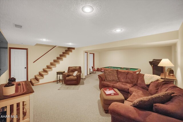 carpeted living room with a textured ceiling and pool table