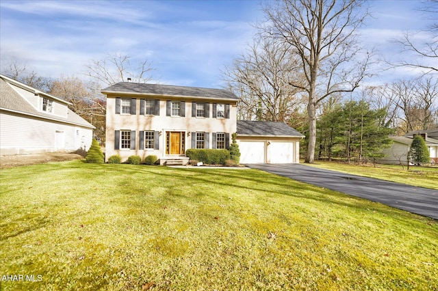 colonial-style house featuring a front yard and a garage