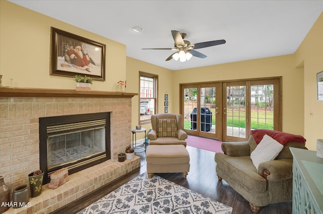 living room featuring ceiling fan, a fireplace, and hardwood / wood-style flooring