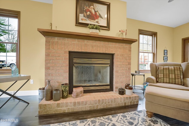 living area featuring hardwood / wood-style flooring and a brick fireplace