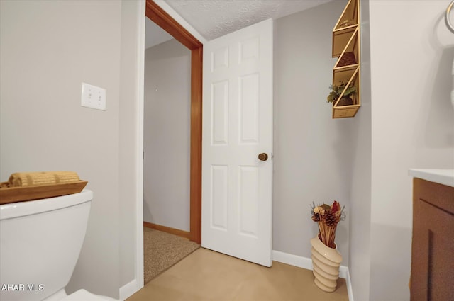 bathroom featuring vanity, a textured ceiling, and toilet